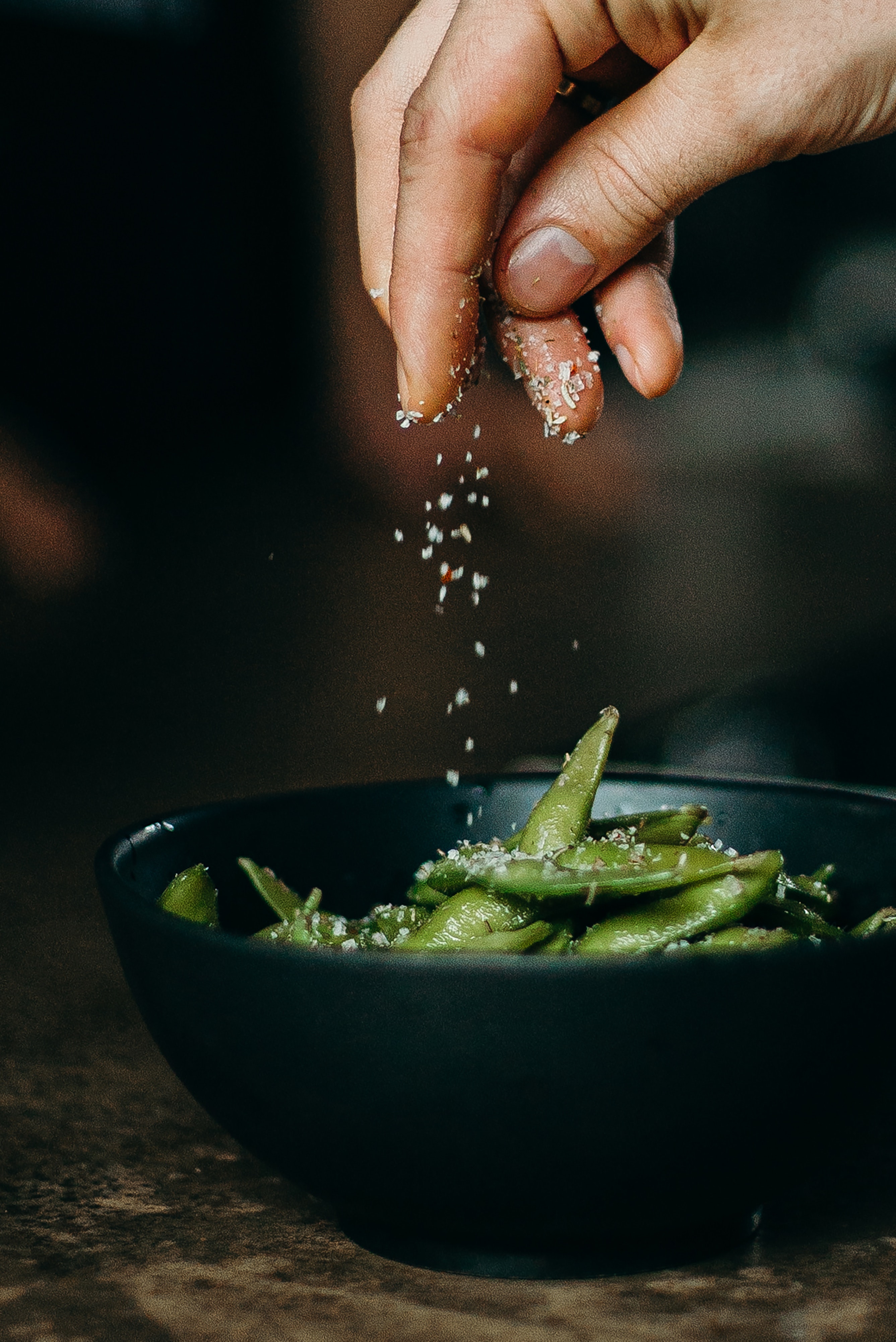 Lunchboys Berlin - Photo by cottonbro studio: https://www.pexels.com/photo/person-pouring-seasoning-on-green-beans-on-bowl-3338497/